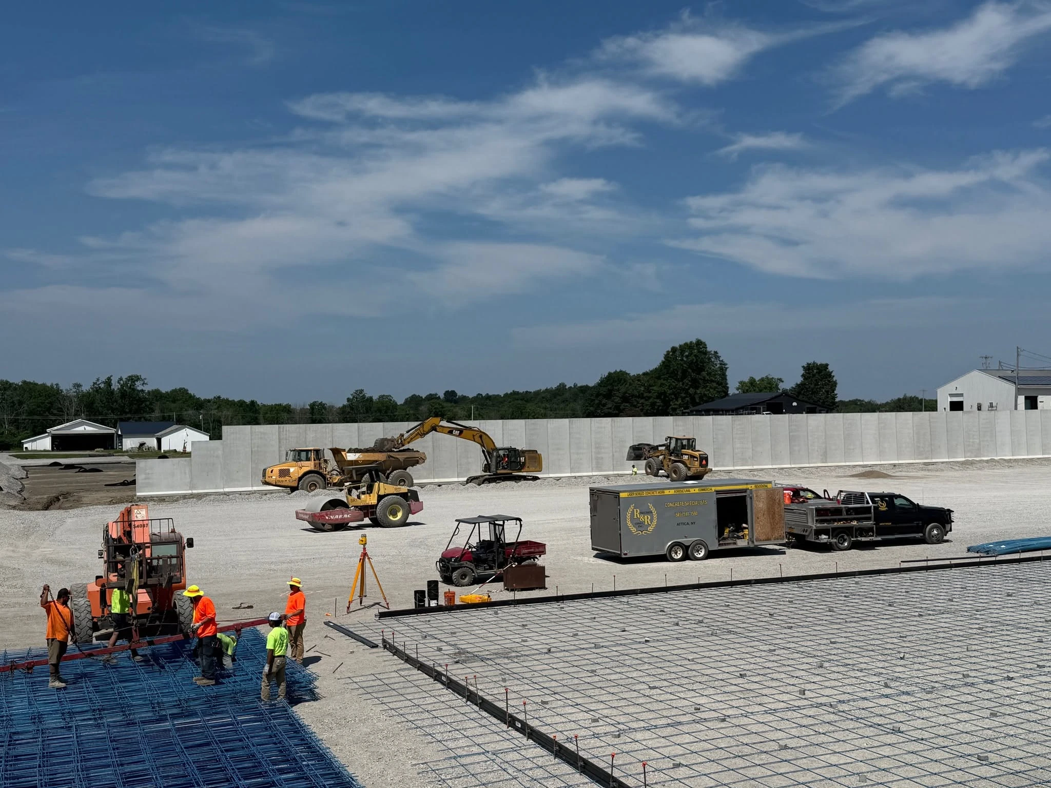 R&R concrete construction site showing a large reinforced slab, crews, equipment and concrete walls
